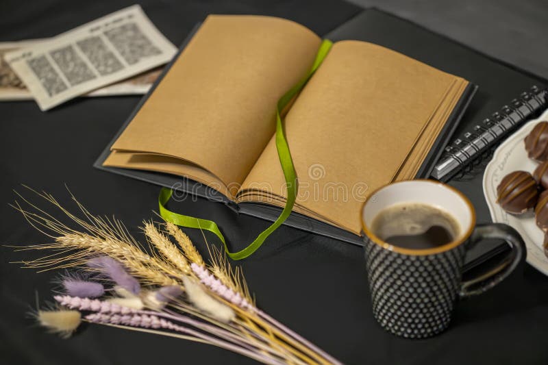 Cioccolatini a base di caffè una tazza di vecchi volantini e di spikelets su fondo nero fotografia stock