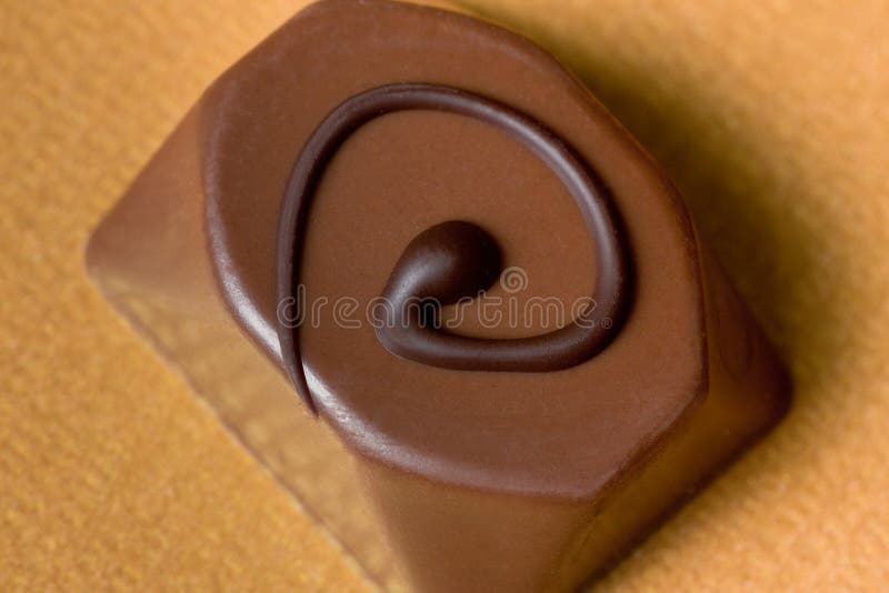 Decadent piece of filled milk chocolate candy with a dark swirl. Decadent piece of filled milk chocolate candy with a dark swirl