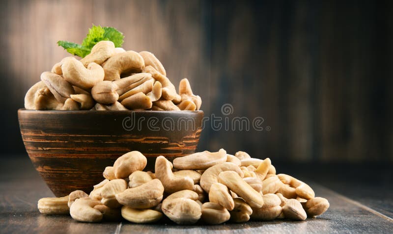 Ciotola con gli anacardi sulla tavola di legno fotografia stock libera da diritti Ciotola con gli anacardi sulla tavola di legno fotografia stock libera da diritti