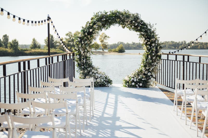 Circle Wedding Arch Decorated with White Flowers and Greenery Outdoors