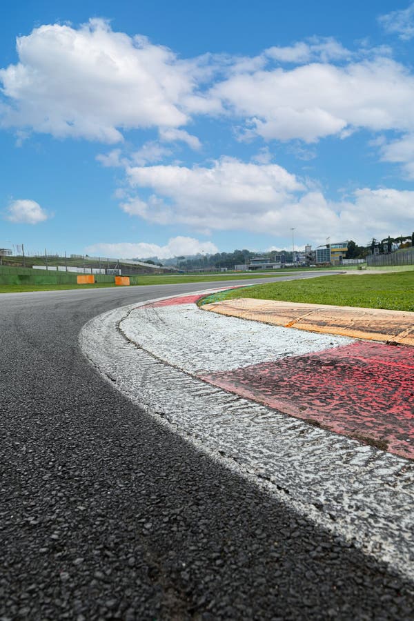 corridas de carros esportivos na estrada de asfalto com cerca azul e sinal  de tráfego de