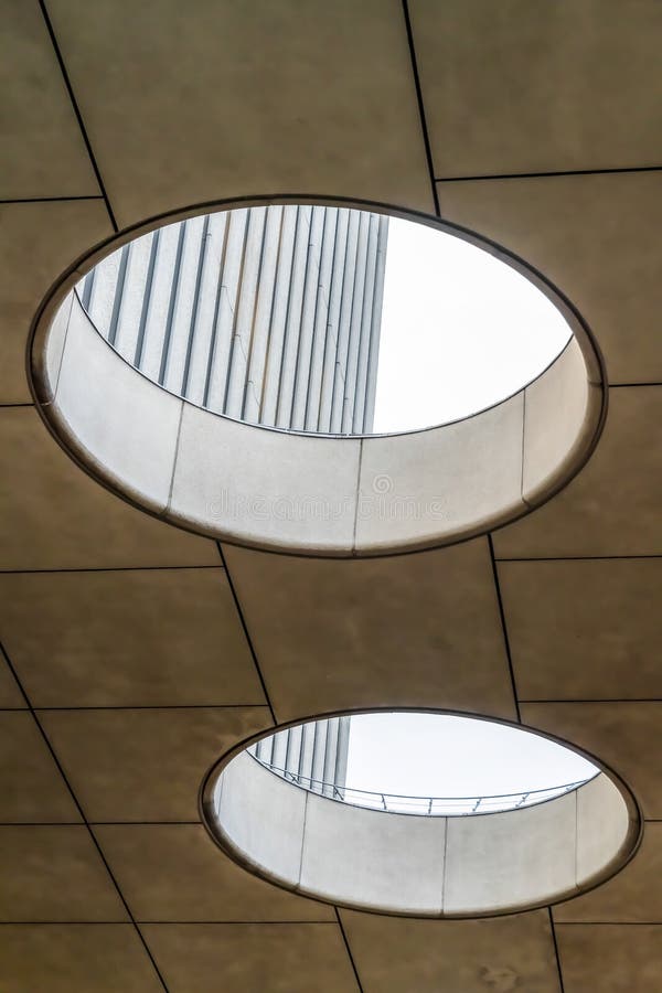 Circular skylights inside a building with view of the concrete exterior wall. A bright white sky can also be seen through the holes stock photography Circular skylights inside a building with view of the concrete exterior wall. A bright white sky can also be seen through the holes stock photography