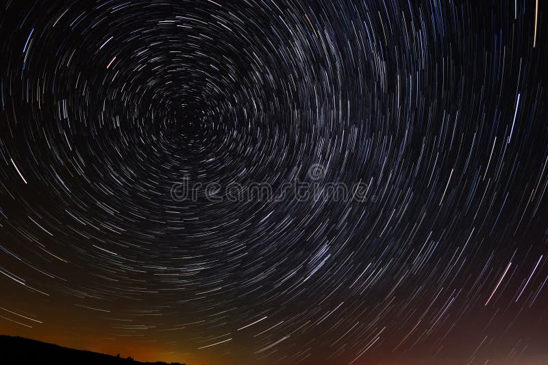 Circular star trails in the sky with a tint of city light from far away