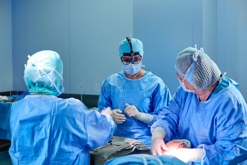 Cirujano que realiza cirug?a cosm?tica en sala de operaciones del hospital Cirujano en lupas que llevan de la m?scara durante pro imagen de archivo Cirujano que realiza cirug?a cosm?tica en sala de operaciones del hospital Cirujano en lupas que llevan de la m?scara durante pro imagen de archivo