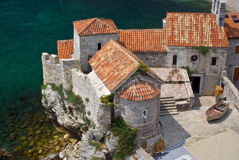 Ancient architecture of old Budva fortess with its red roofs, church, stoned walls and cute little backyard (Montenegro, South Europe). Ancient architecture of old Budva fortess with its red roofs, church, stoned walls and cute little backyard (Montenegro, South Europe).