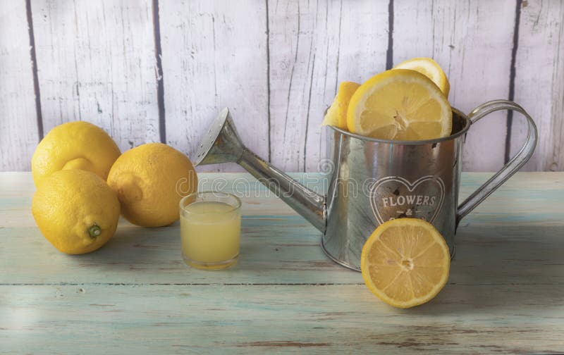 Citrons et jus de citron entiers et coupés en tranches image stock Citrons et jus de citron entiers et coupés en tranches image stock
