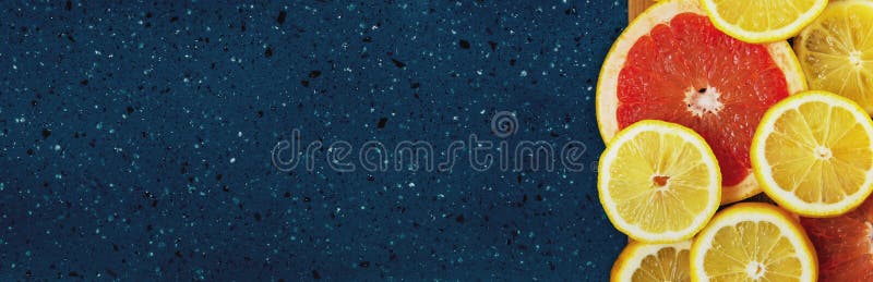 Citrus slices on a blue background. Citrus slices: lemon, grapefruit. Banner. Menu. Panorama.