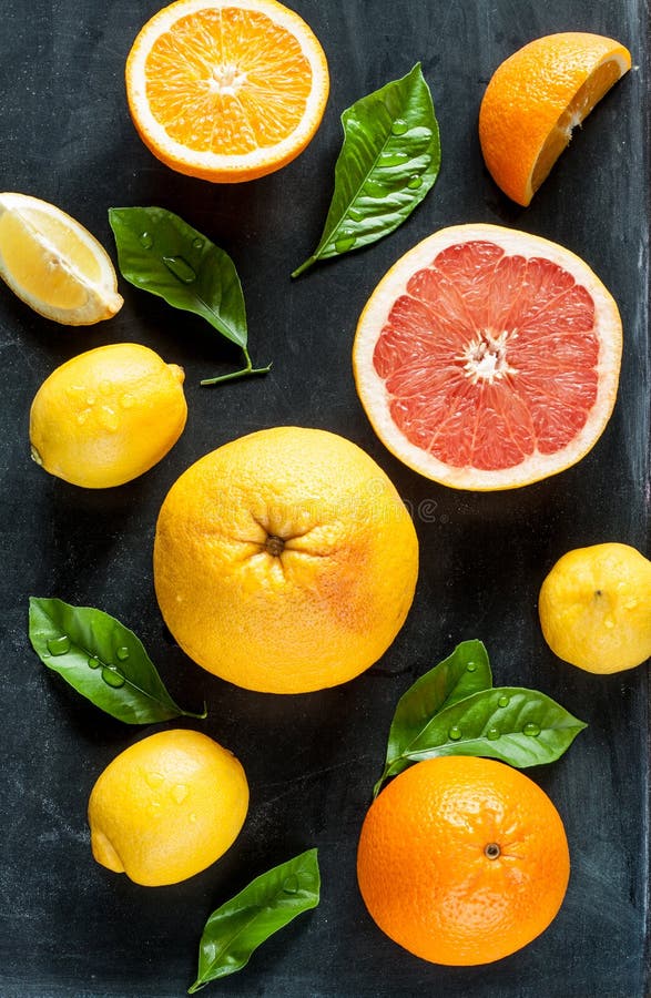 Citrusvruchten (citroen, grapefruit en sinaasappel) op zwart bord royalty-vrije stock afbeeldingen Citrusvruchten (citroen, grapefruit en sinaasappel) op zwart bord royalty-vrije stock afbeeldingen