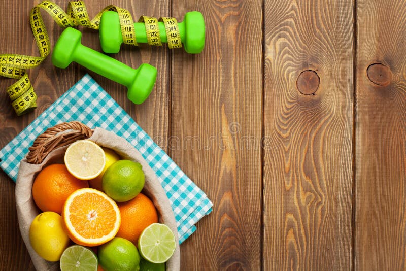 Citrusvruchten in mand en dumbells Sinaasappelen, kalk en citroenen stock afbeeldingen Citrusvruchten in mand en dumbells Sinaasappelen, kalk en citroenen stock afbeeldingen