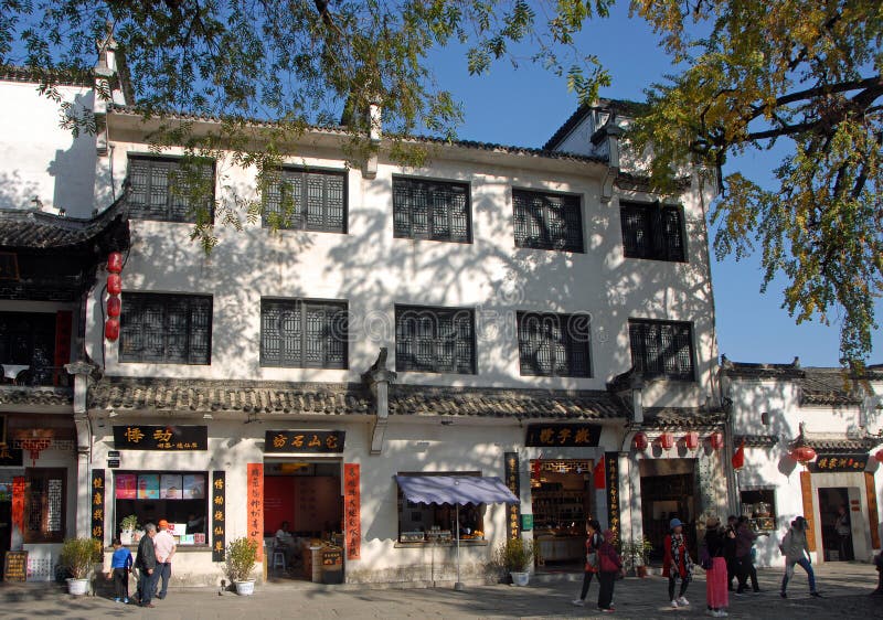 Città antica di Hongcun, provincia di Anhui, Cina Persone che camminano all'ombra di un gingko o di un maidenhair immagini stock Città antica di Hongcun, provincia di Anhui, Cina Persone che camminano all'ombra di un gingko o di un maidenhair immagini stock