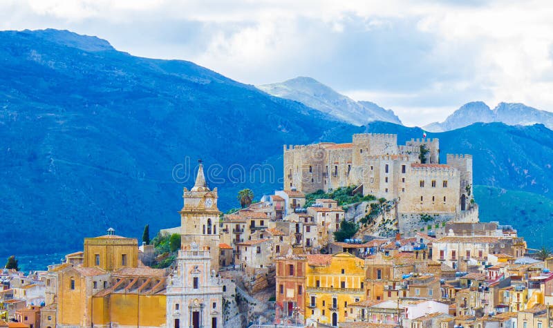 Città di Caccamo sulla collina con il fondo delle montagne il giorno nuvoloso in Sicilia fotografia stock libera da diritti Città di Caccamo sulla collina con il fondo delle montagne il giorno nuvoloso in Sicilia fotografia stock libera da diritti