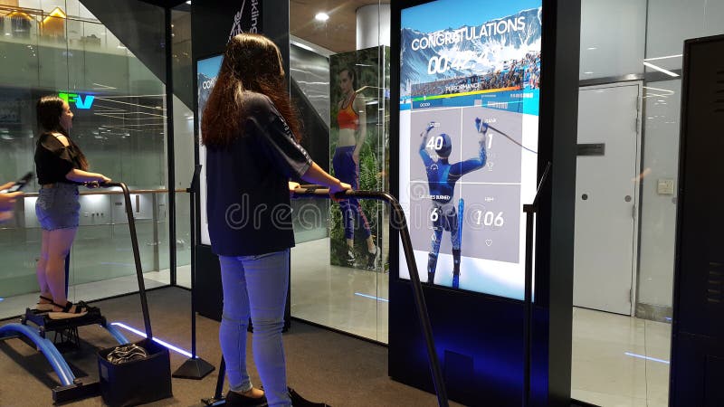 Città di Ho Chi Minh, Vietnam - 27 aprile 2019: Due ragazze stanno giocando i giochi dello sci con la tecnologia assistive più mo fotografia stock libera da diritti Città di Ho Chi Minh, Vietnam - 27 aprile 2019: Due ragazze stanno giocando i giochi dello sci con la tecnologia assistive più mo fotografia stock libera da diritti