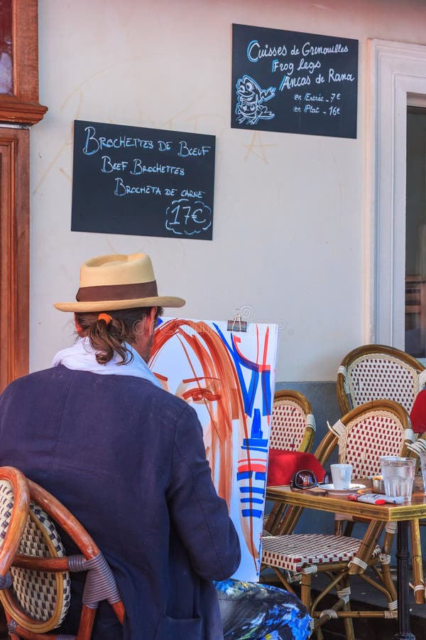 City landscape - view of the Parisian cafe in Montmartre with the artist who paints a portrait, on a summer day in Paris, France, 18 July, 2016