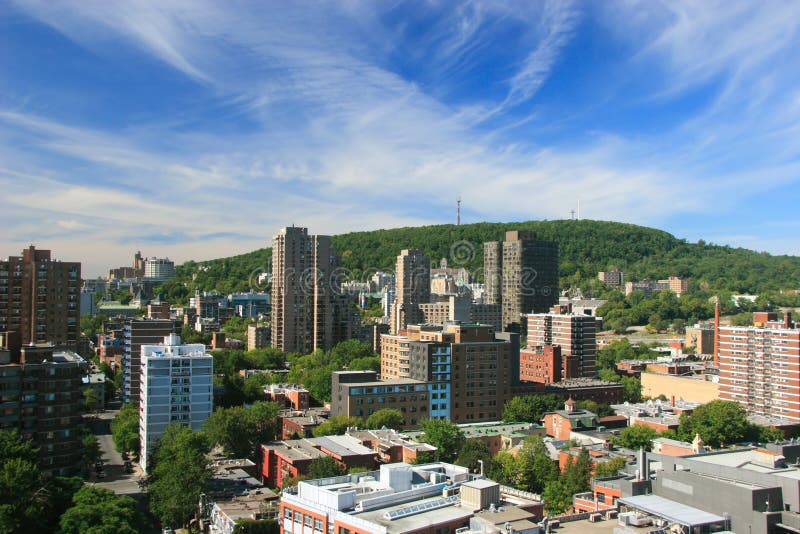 Toto je výhľad na mesto Montreal, Quebec, Kanada s Mount Royal v pozadí a modré nebo s výpary mraky.