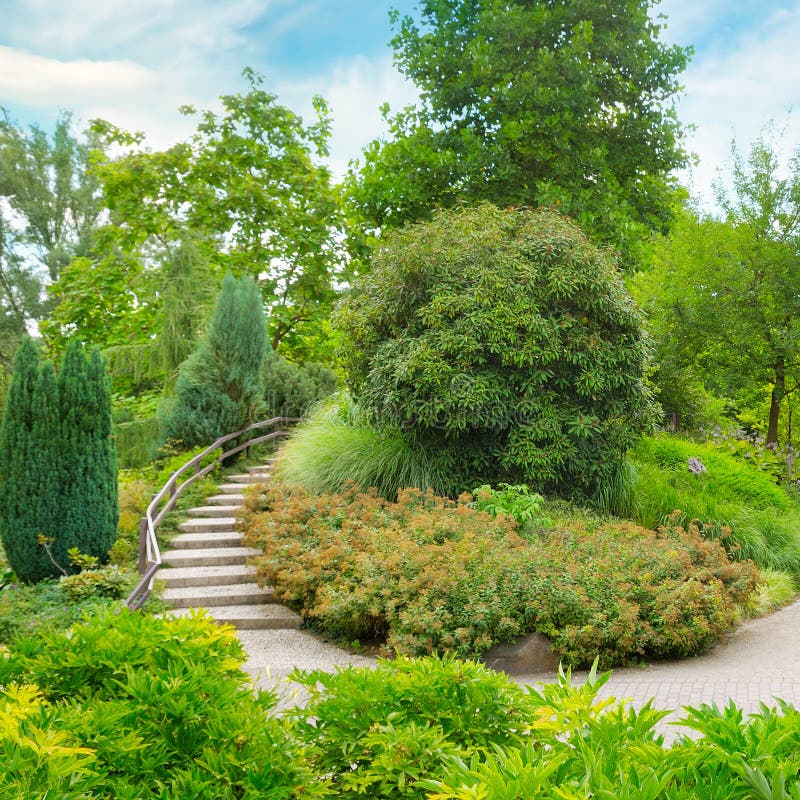 City park with beautiful trees, shrubs and staircase royalty free stock photos