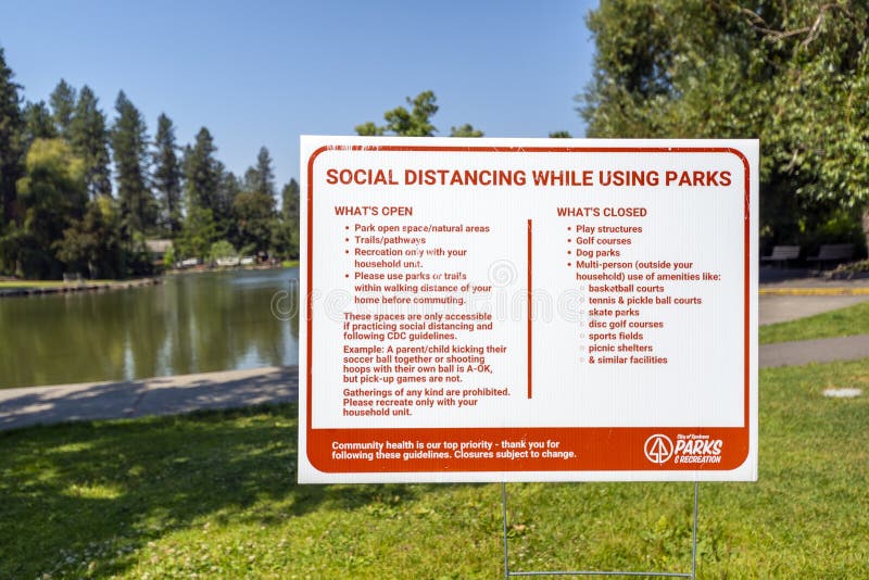 A city park sign in Spokane Washington`s public Manito Park offer social distancing information and guidelines royalty free stock photography A city park sign in Spokane Washington`s public Manito Park offer social distancing information and guidelines royalty free stock photography