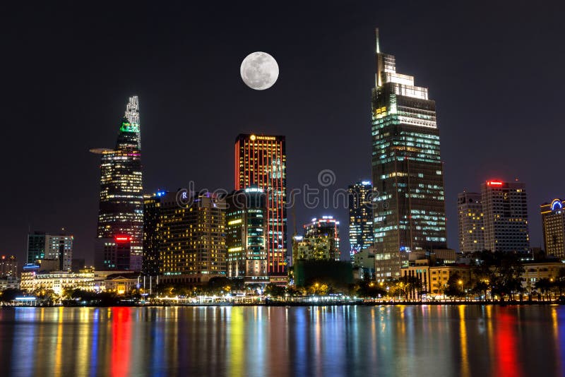 City Scene with The Moon Rising above Ho Chi Minh City&x27;s Central Business District by Night