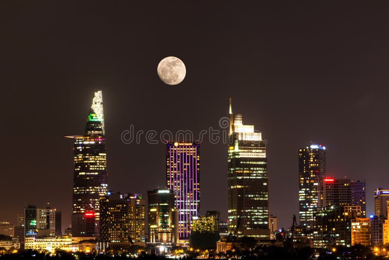 City Scene with The Moon Rising above Ho Chi Minh City&x27;s Central Business District by Night