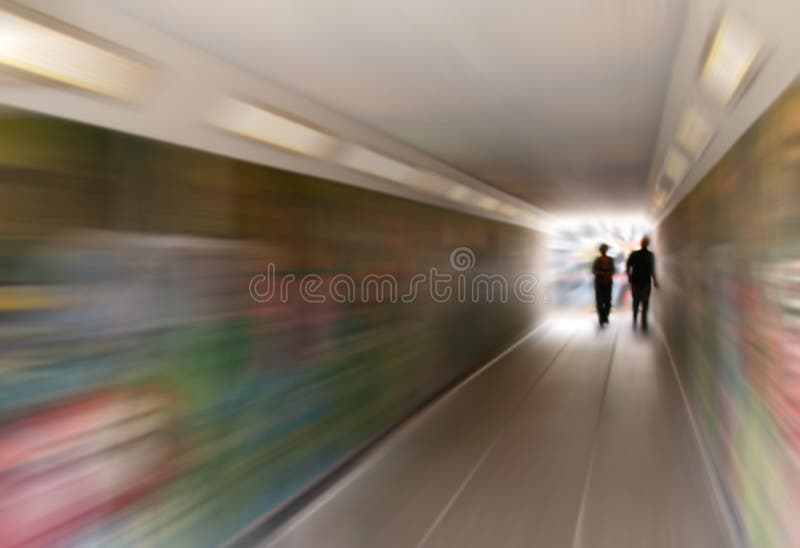 Urban blur as Man and Woman wander to City Centre from Office Blocks and Car Park using underpass, with man casually trailling hand along wall. Urban blur as Man and Woman wander to City Centre from Office Blocks and Car Park using underpass, with man casually trailling hand along wall.