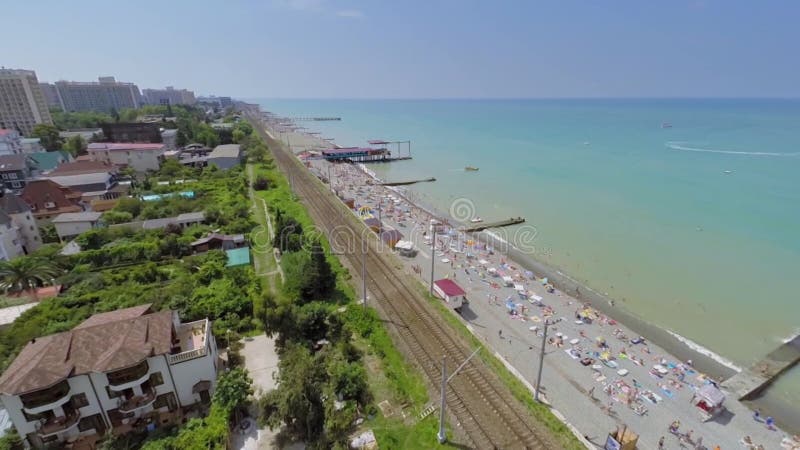 Ciudad costera y ferrocarril cerca de la playa del mar con mucho almacen de video