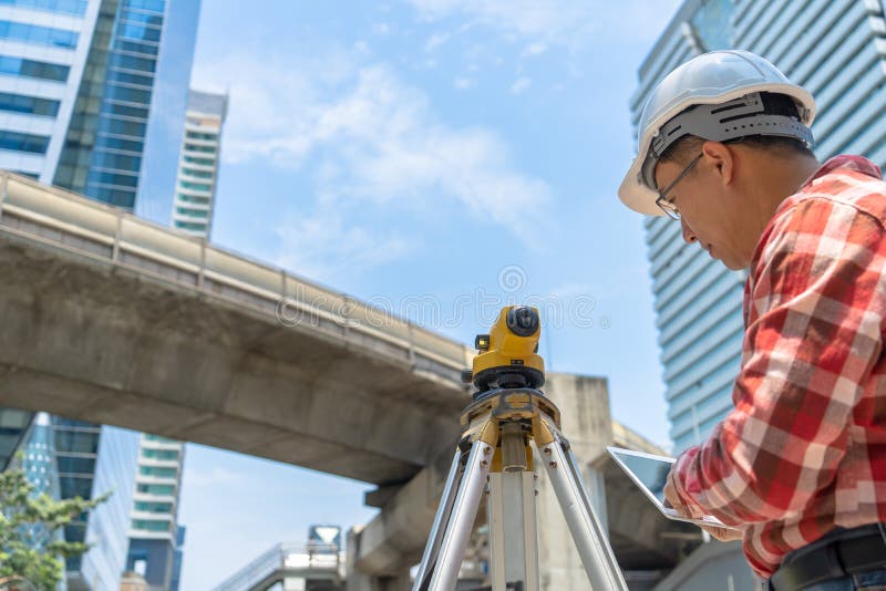 Civil engineer land survey with tacheometer or theodolite equipment. Worker Checking construction site on the road. Surveyor engineer making measuring with theodolite instrument level tool.