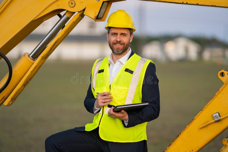 Civil engineer worker at a construction site. Engineer man in front of house background. Confident engineer worker at modern home stock photography