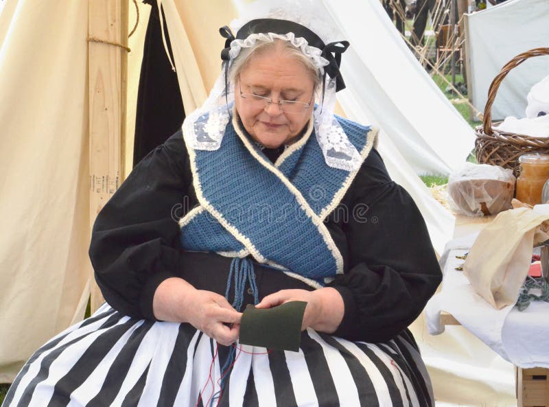 DEARBORN, MI - MAY 26: Civil-war era re-enactor sewing during the Civil War remembrance at Greenfield Village May 26, 2013. DEARBORN, MI - MAY 26: Civil-war era re-enactor sewing during the Civil War remembrance at Greenfield Village May 26, 2013.