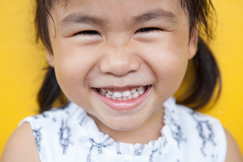 Ciérrese encima de cara de la cara facial sonriente dentuda del niño asiático con happi