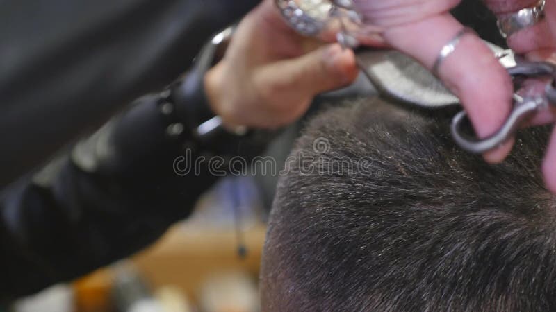 Ciérrese encima de corte de pelo en la peluquería de caballeros con las tijeras