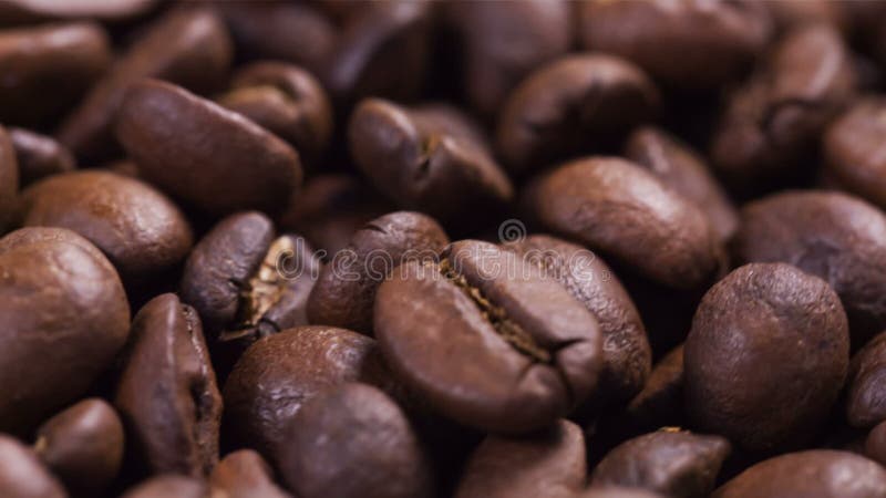 Ciérrese encima de la cantidad de girar los granos de café asados