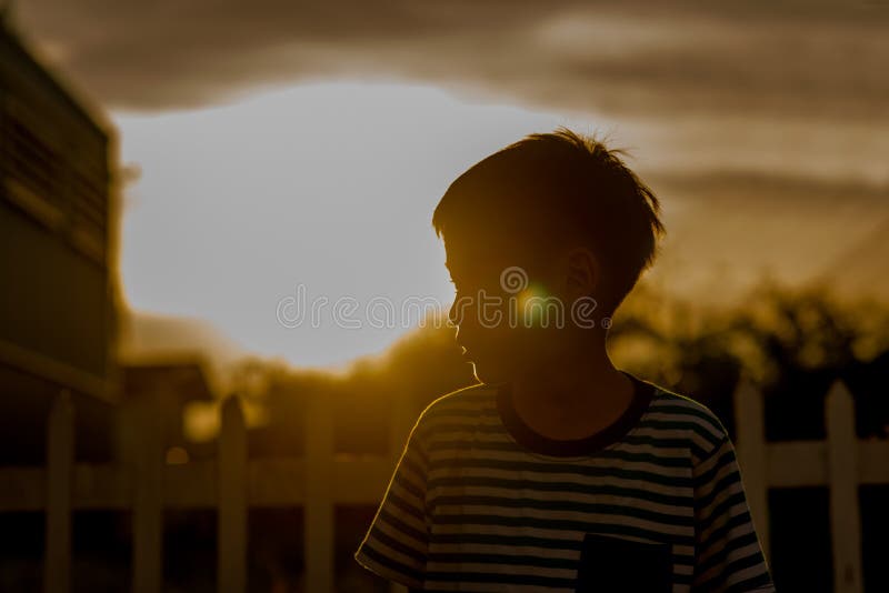 Ciérrese encima de la cara feliz del muchacho al aire libre en el tiempo de la puesta del sol blanco y negro fotografía de archivo libre de regalías Ciérrese encima de la cara feliz del muchacho al aire libre en el tiempo de la puesta del sol blanco y negro fotografía de archivo libre de regalías