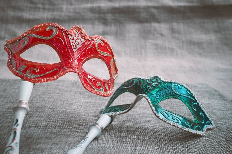 Ciérrese encima de la mascarada veneciana roja y verde, lugar en la harpillera de la arpillera, visión superior de la máscara del fotografía de archivo libre de regalías Ciérrese encima de la mascarada veneciana roja y verde, lugar en la harpillera de la arpillera, visión superior de la máscara del fotografía de archivo libre de regalías