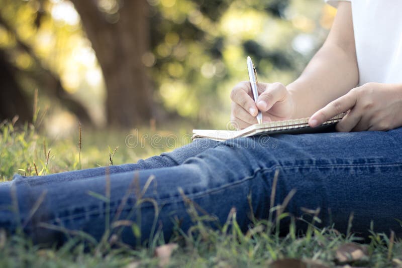 ciérrese encima de las mujeres jovenes que escriben en el cuaderno en el parque, concepto en edu foto de archivo libre de regalías ciérrese encima de las mujeres jovenes que escriben en el cuaderno en el parque, concepto en edu foto de archivo libre de regalías