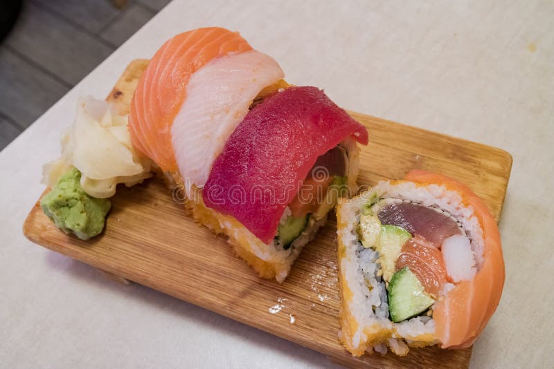Ciérrese encima de tiro de un sushi delicioso del rollo del arco iris del estilo japonés fotos de archivo Ciérrese encima de tiro de un sushi delicioso del rollo del arco iris del estilo japonés fotos de archivo