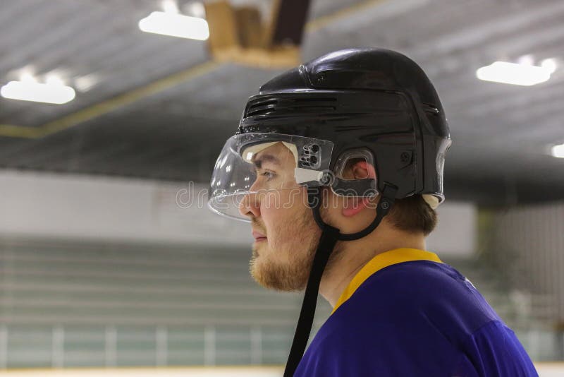 Ciérrese encima de vista lateral de un hombre joven que lleva un casco del hockey imagen de archivo libre de regalías Ciérrese encima de vista lateral de un hombre joven que lleva un casco del hockey imagen de archivo libre de regalías