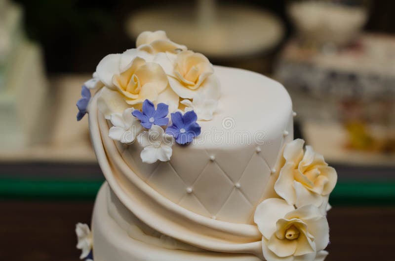Ciérrese encima del pastel de bodas con las flores amarillas y púrpuras fotografía de archivo libre de regalías Ciérrese encima del pastel de bodas con las flores amarillas y púrpuras fotografía de archivo libre de regalías