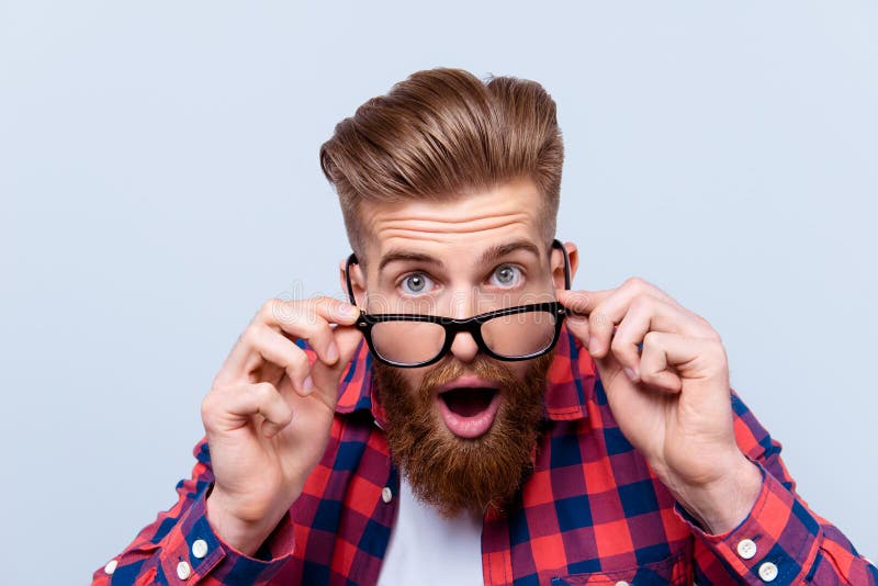 Ciérrese encima del retrato del hombre sorprendente chocado en tacto a cuadros de la camisa fotografía de archivo
