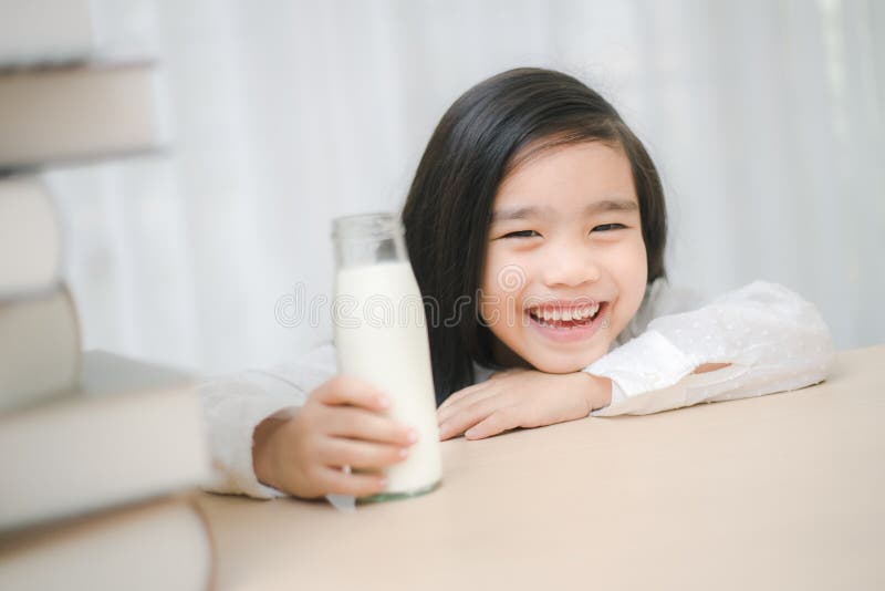Ciérrese encima del retrato del pequeño vidrio de consumición asiático adorable de la muchacha o fotografía de archivo Ciérrese encima del retrato del pequeño vidrio de consumición asiático adorable de la muchacha o fotografía de archivo