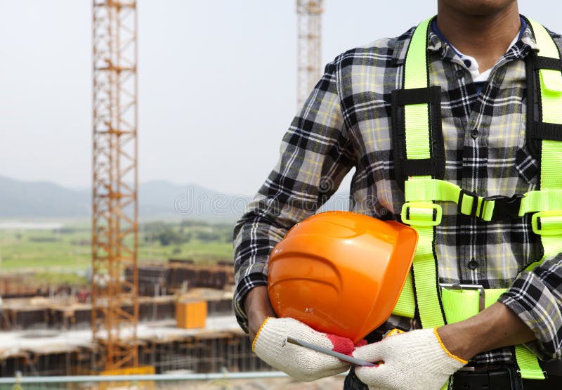 Ciérrese encima del trabajador de construcción que sostiene el casco