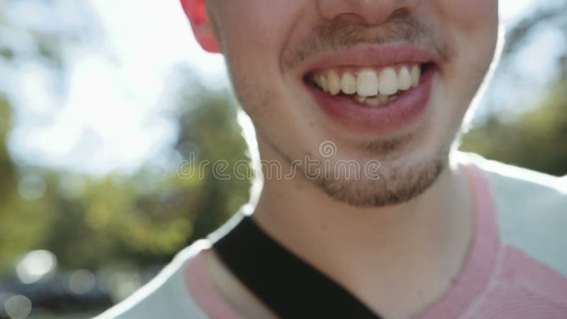 Ciérrese para arriba de la cara alegre del hombre joven que sonríe extensamente