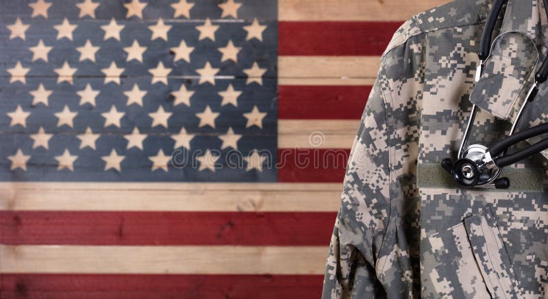 Closeup of military uniform with stethoscope against faded boards painted in USA flag background. Healthcare concept for American soldiers. Closeup of military uniform with stethoscope against faded boards painted in USA flag background. Healthcare concept for American soldiers.