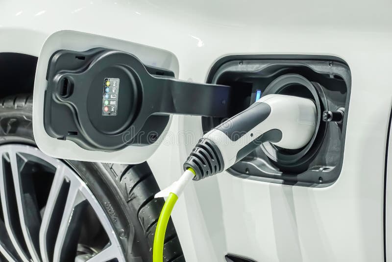 Ciérrese para arriba de la fuente de alimentación tapada en un coche eléctrico que es cargado fotografía de archivo libre de regalías Ciérrese para arriba de la fuente de alimentación tapada en un coche eléctrico que es cargado fotografía de archivo libre de regalías