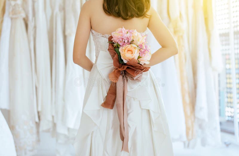 Ciérrese para arriba de la mano de la mujer de la novia que sostiene un behide del ramo su parte posterior para el momento que se imagen de archivo libre de regalías Ciérrese para arriba de la mano de la mujer de la novia que sostiene un behide del ramo su parte posterior para el momento que se imagen de archivo libre de regalías