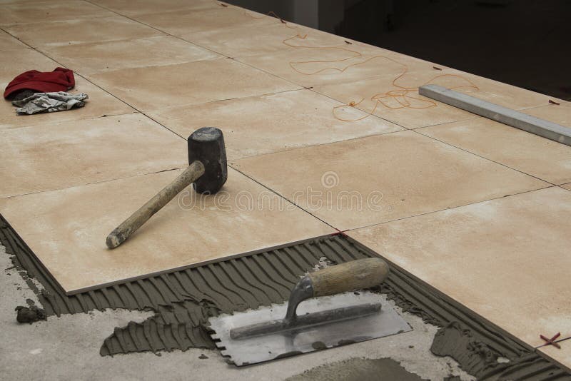 Ciérrese para arriba de las herramientas de un trabajador en un piso se esté tejando que foto de archivo Ciérrese para arriba de las herramientas de un trabajador en un piso se esté tejando que foto de archivo