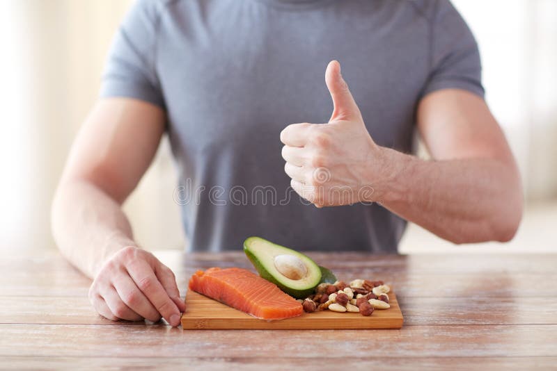 Ciérrese para arriba de las manos masculinas con ricos de la comida en proteína