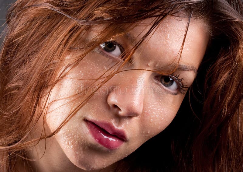 A portrait of a model with wet hair and water droplets on her face. A portrait of a model with wet hair and water droplets on her face