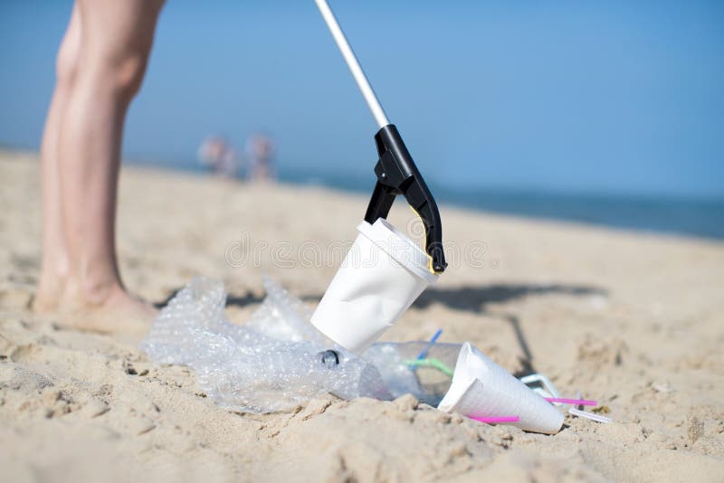 Ciérrese para arriba de Person Collecting Plastic Waste From contaminó la playa