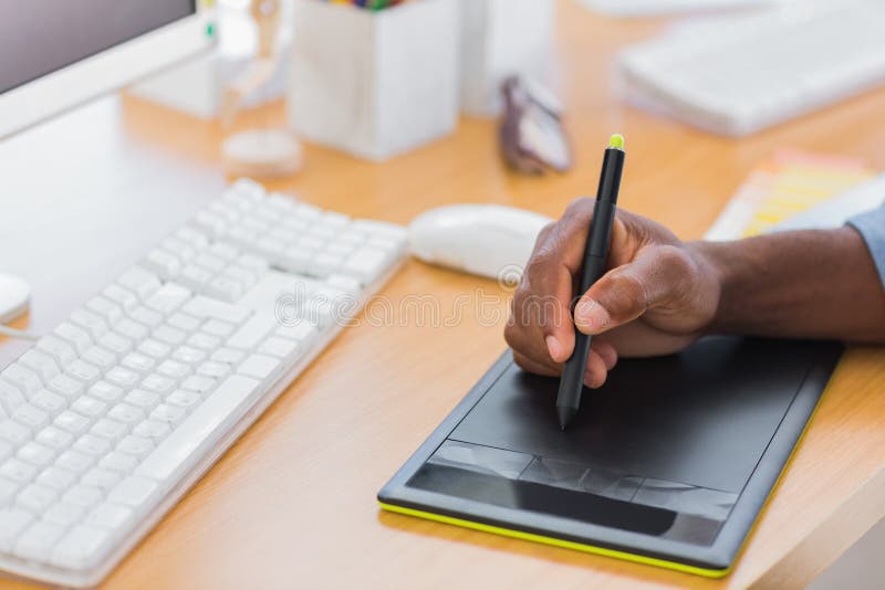 Close up of a graphic designer using graphics tablet in a modern office. Close up of a graphic designer using graphics tablet in a modern office