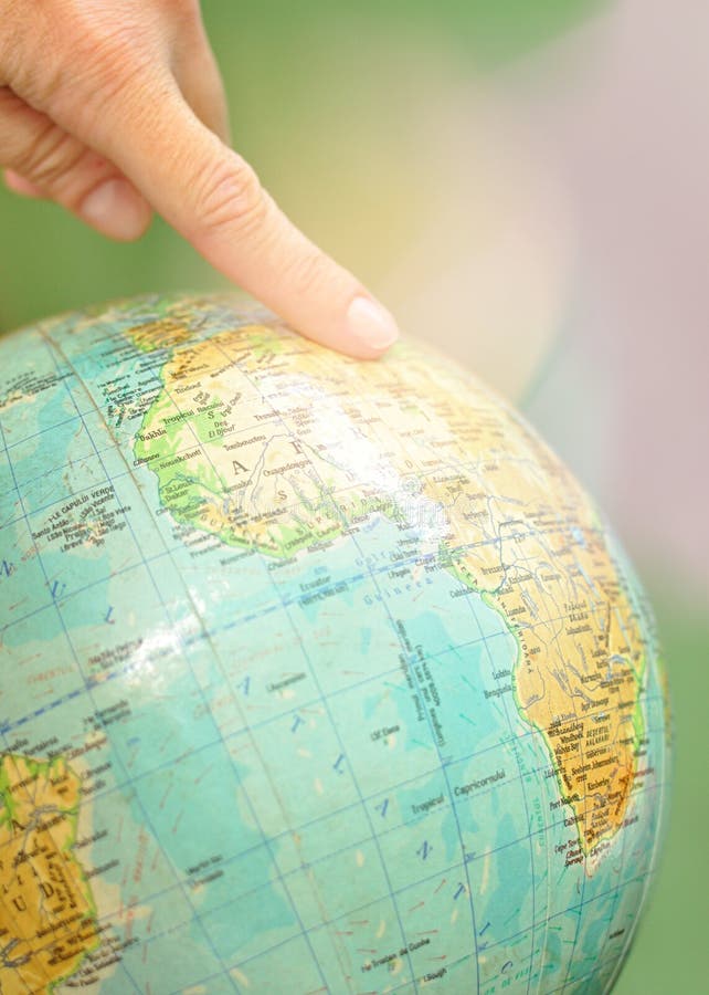 Ciérrese para arriba de un mapa del mundo del globo con un dedo índice en él fotografía de archivo libre de regalías Ciérrese para arriba de un mapa del mundo del globo con un dedo índice en él fotografía de archivo libre de regalías