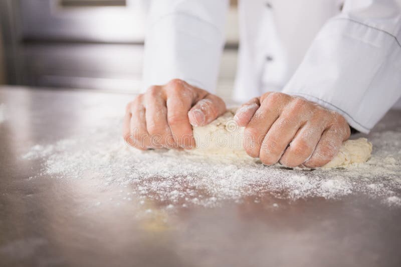 Close up of baker preparing dough in the kitchen of the bakery. Close up of baker preparing dough in the kitchen of the bakery